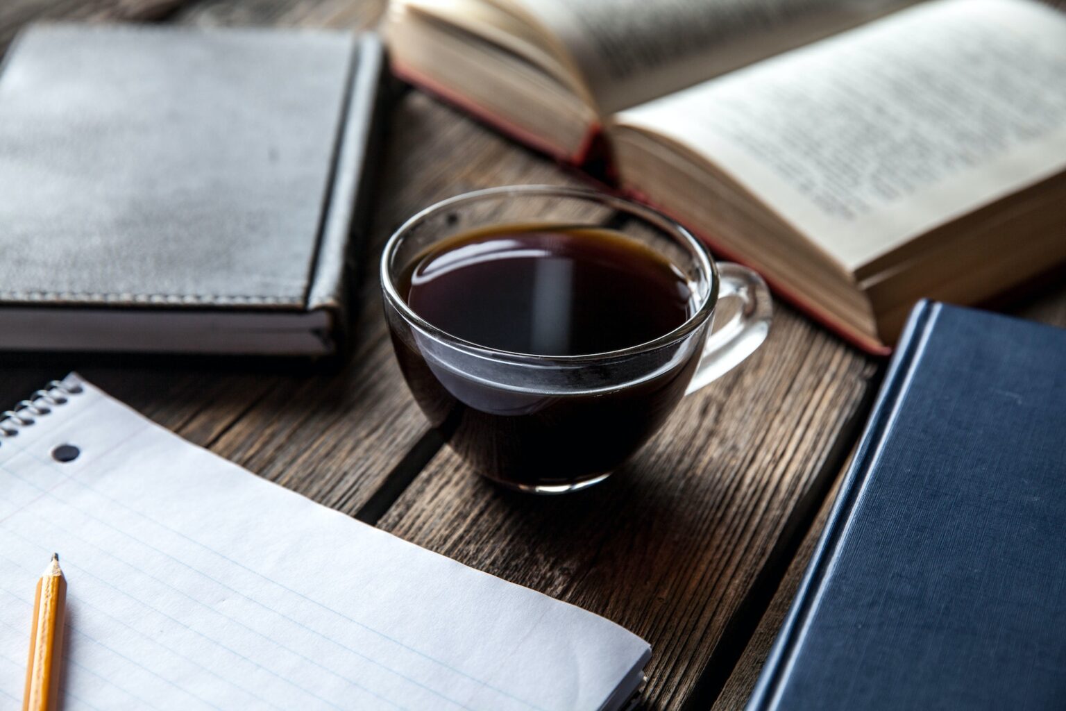 books and a cup of coffee on a wooden background